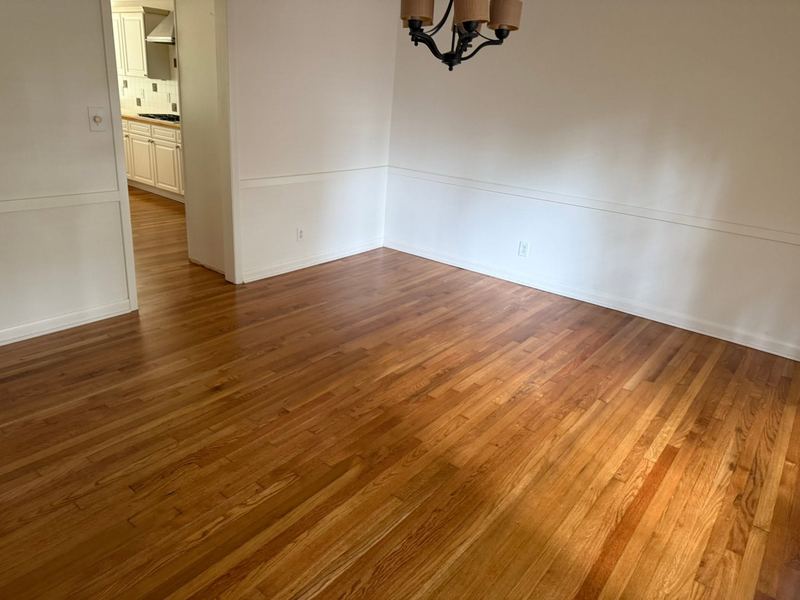 Empty dining room with a natural amber red oak floor