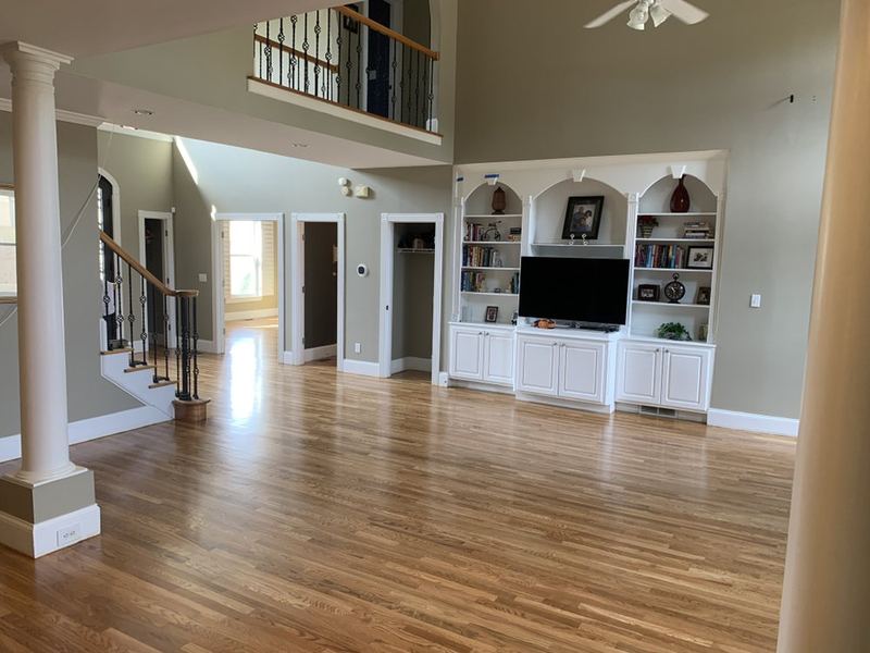 Two-story family room with built-ins and a natural oak floor
